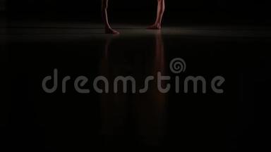 女子运动员在艺术体操中进行运动的苗条腿的特写，地板上有美丽的倒影